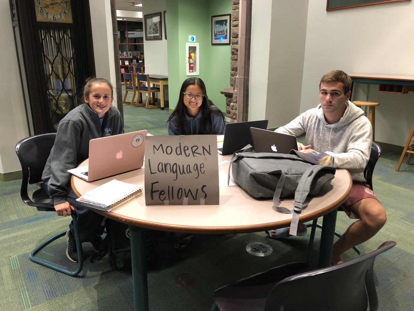 Modern Language Fellows Marina Mendez ’19 and Ivy Yan ’18 are on duty on the first floor of the library while Vince Petrone ’18 receives help. Photo by Rita Vo '19