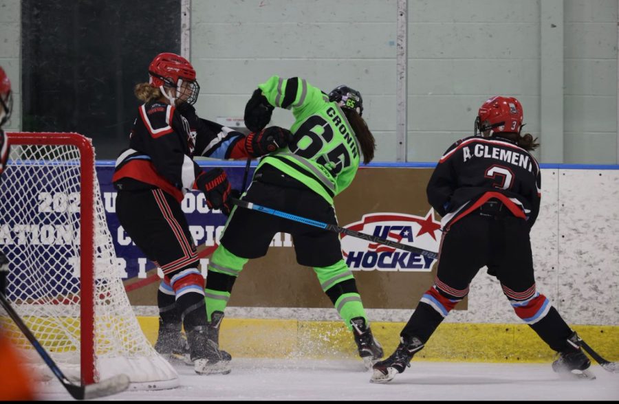Brooke Heck 22 (left) engages in a play against the boards. Photo courtesy of Brooke Heck 22