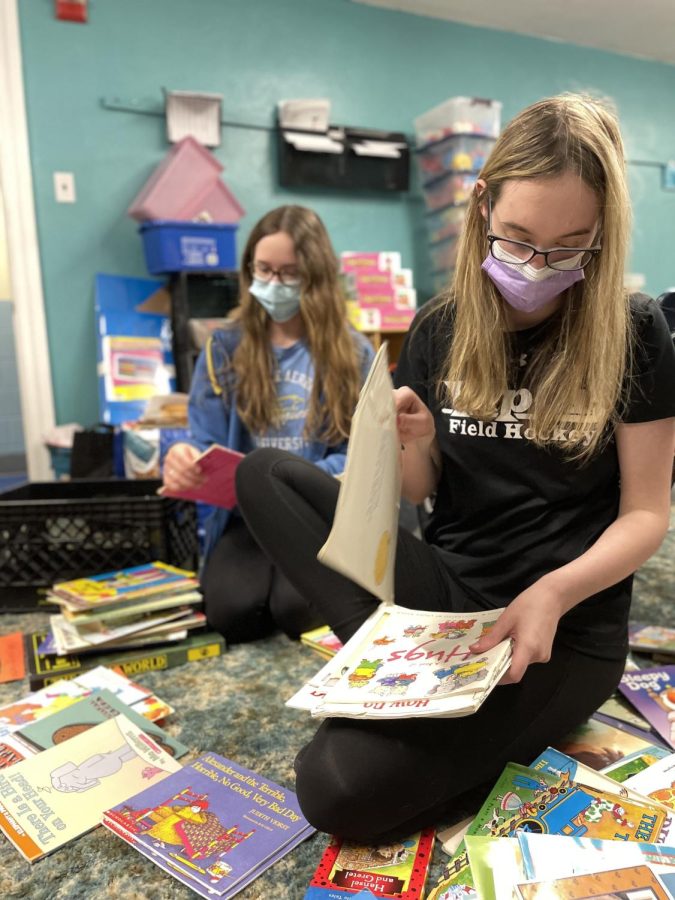 Caroline Grable ’25 and Morgan McMahon’24 sort books according to different colors.