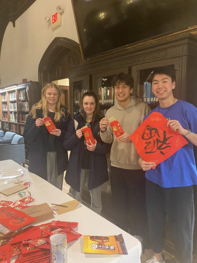 Katie Torr ’25, Avery Cohen ’26, Eddie Li ’23 and Jason Zhou ’23 share the joy of lunar new year with red packets and calligraphy.