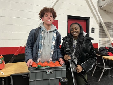 Varsity boys basketball managers Toole ’25 and Robinson ’23 handle the equipment at an away game against Lawrenceville.